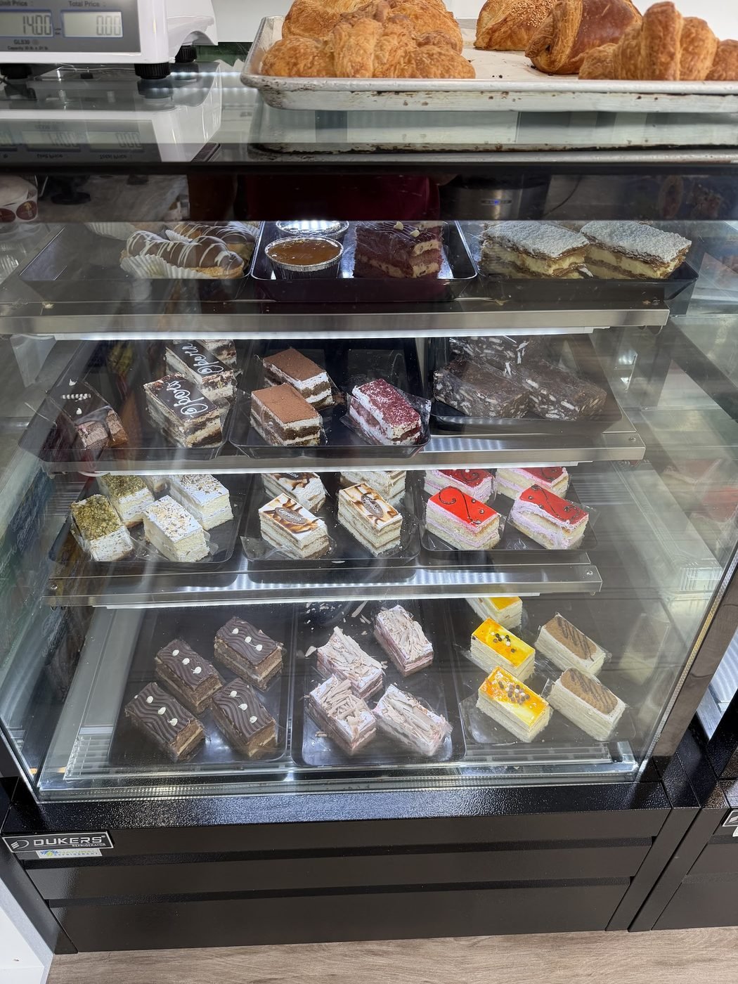 Display case filled with rows of cakes and pastries
