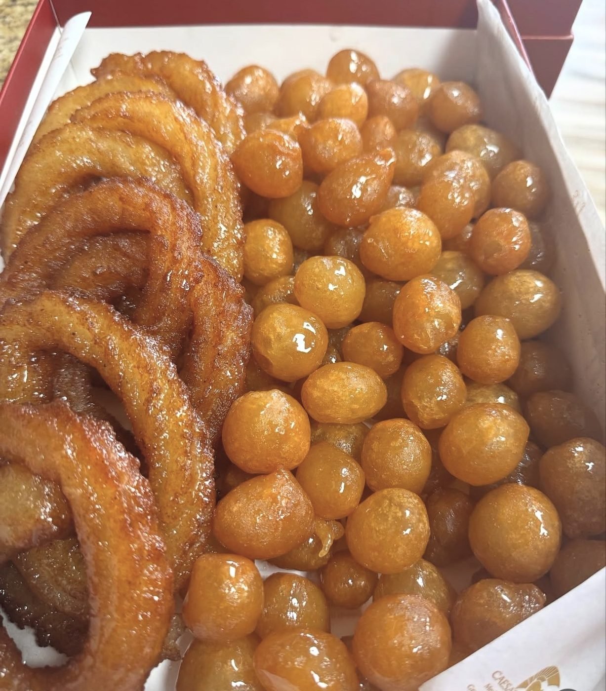 Syrup-glazed fried pastries in a box